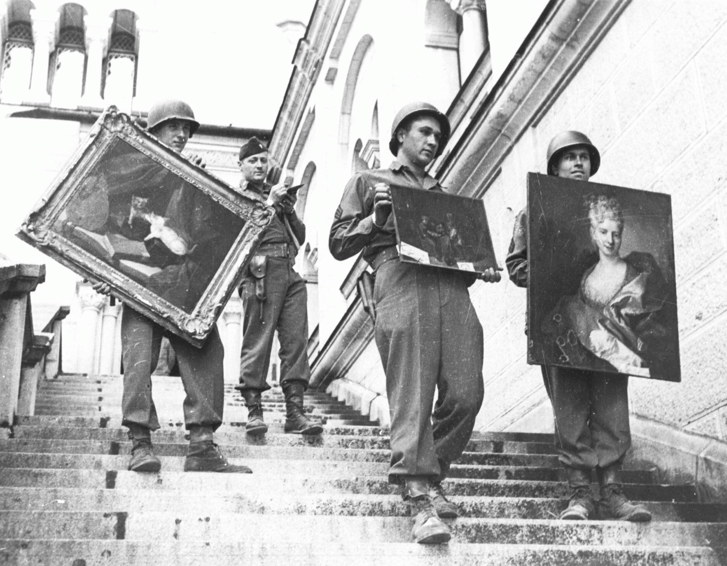 Militairen tonen schilderijen die door de Nazis geroofd en verborgen waren. Van sommigen is de herkomst bekend, van anderen moet die nog bepaald worden